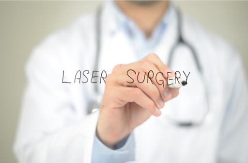 Ophthalmologist writing LASER SURGERY on a clear board
