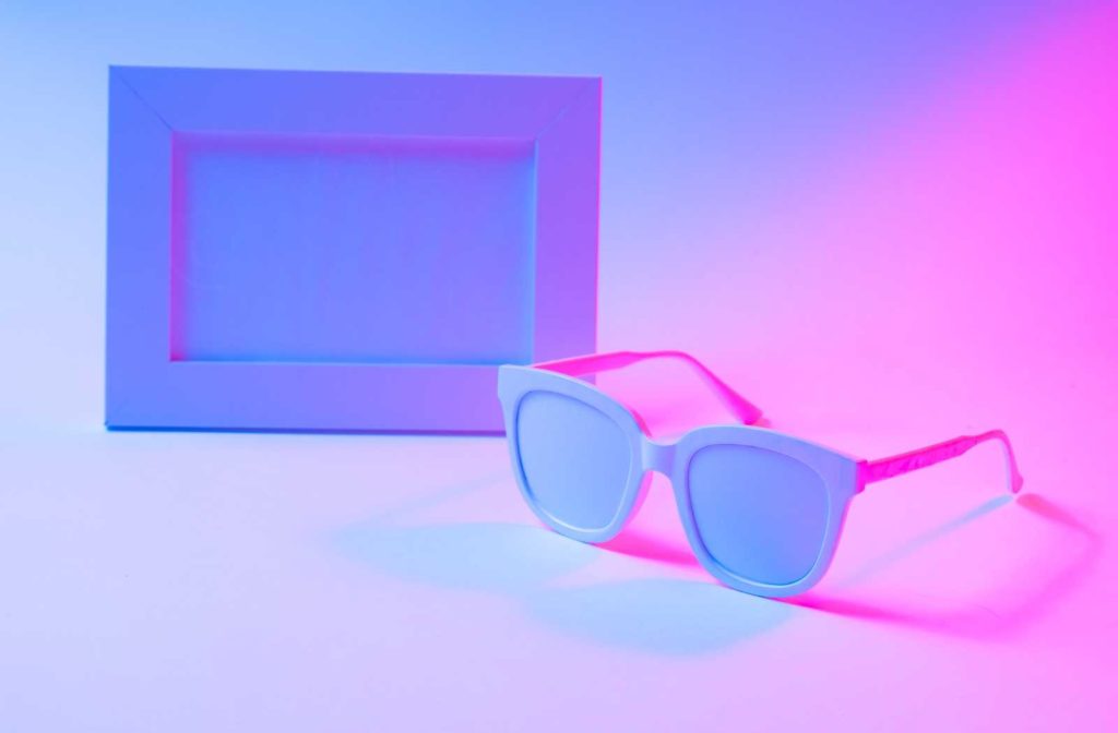 conceptual white eyeglass and picture frames backlit by neon colours