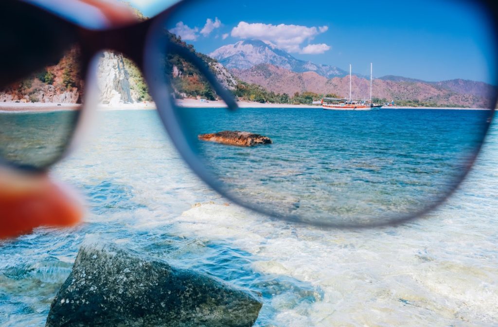 A pair of polarized sunglasses reducing glare off of ocean water