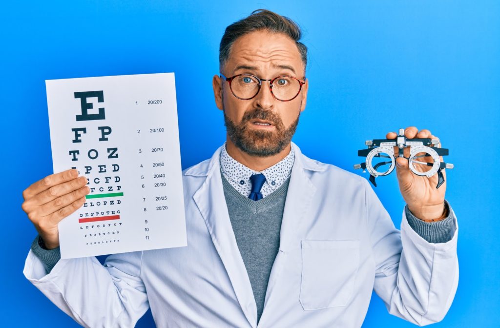 Confused man holding a vision test and optometry glasses