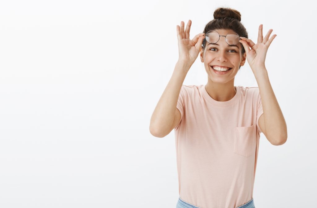 A woman smiling as she doesn't need her glasses after Lasik surgery to see clearly