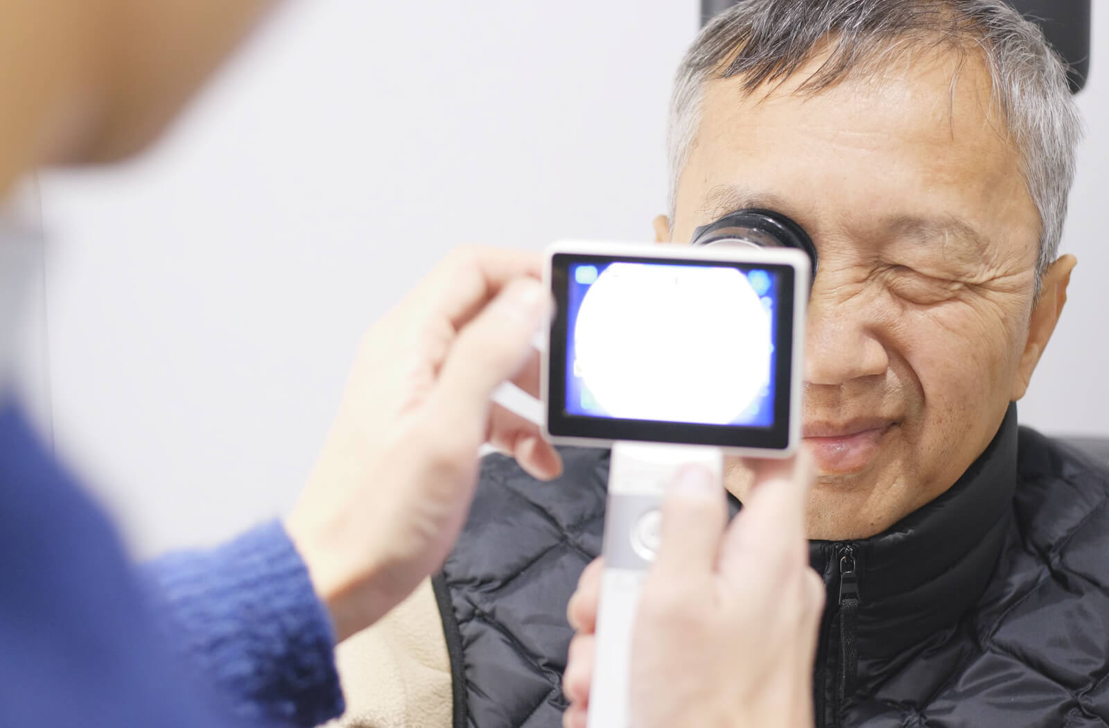 A senior man is getting a retinal imaging exam at an eye care practice.