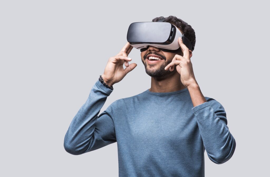 A man using a VR headset and smiling.