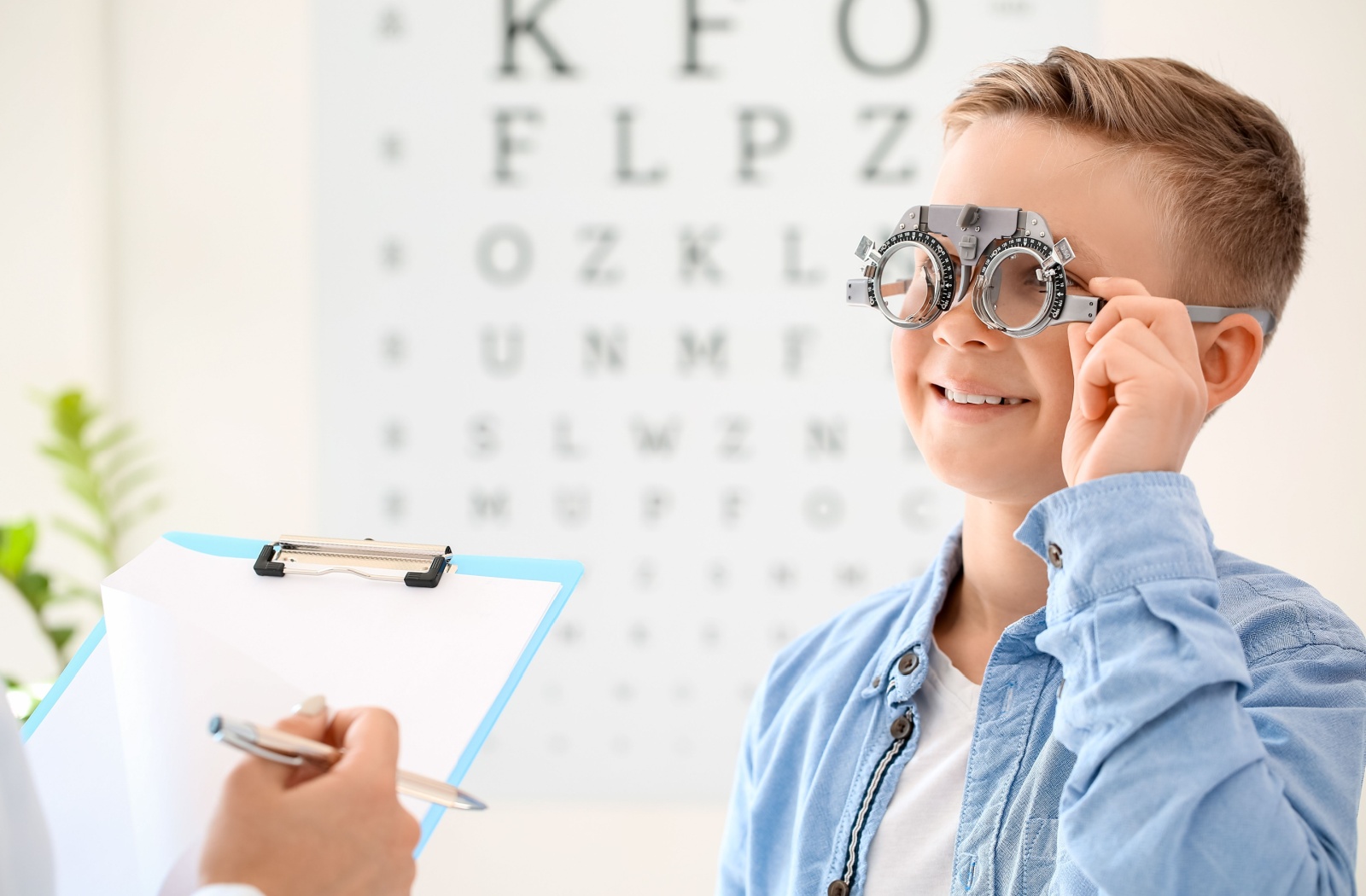 A young boy undergoes an eye exam with an eye chart