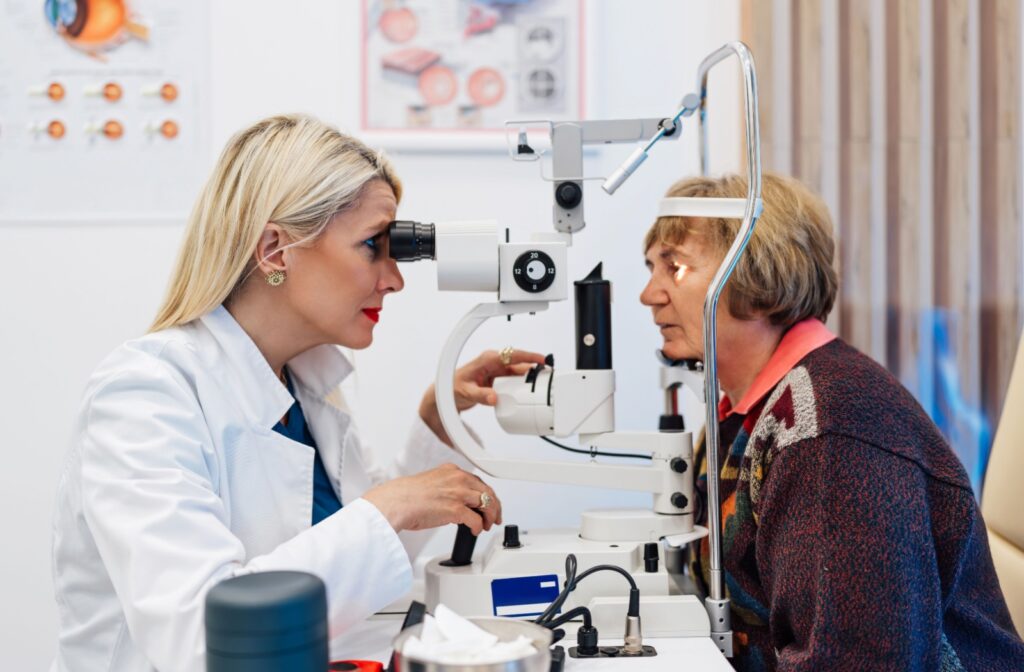 A side view of an optometrist carefully examining an older patient's eyes during a comprehensive eye exam.