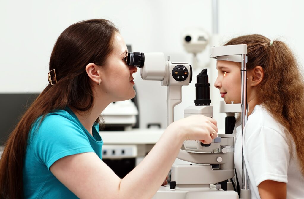 An optometrist examines a child's eyes for myopia during an eye exam.