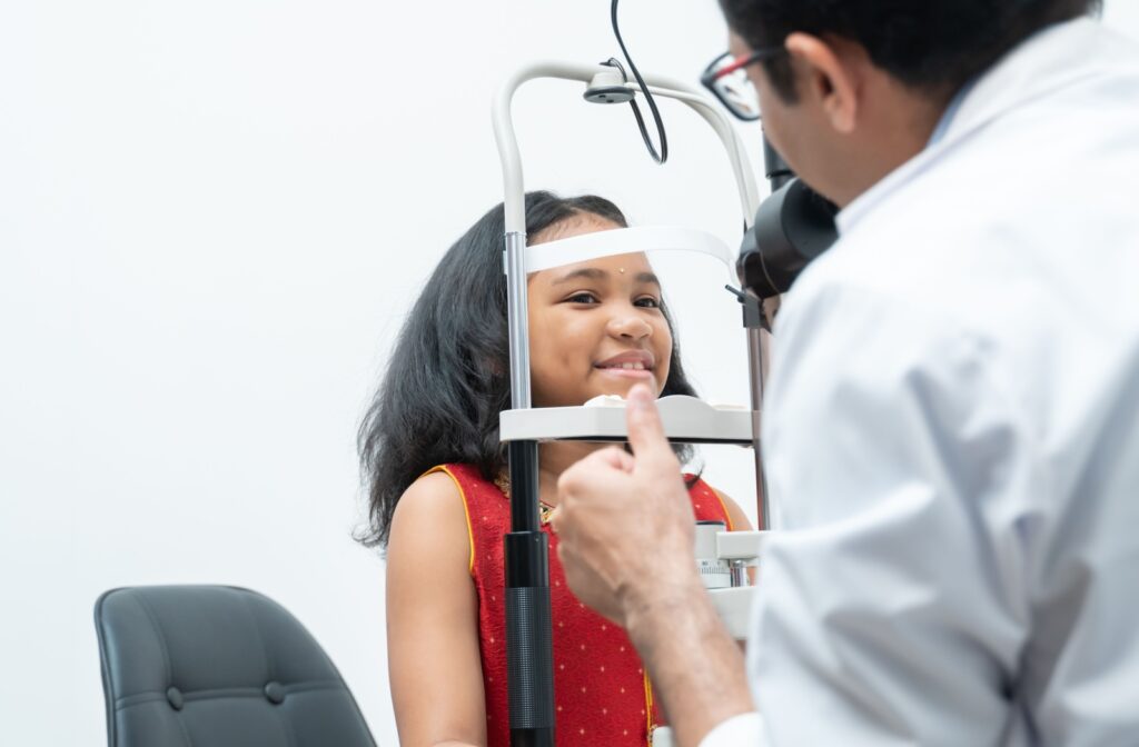 An optometrist examines a child's eyes for myopia during an eye exam.